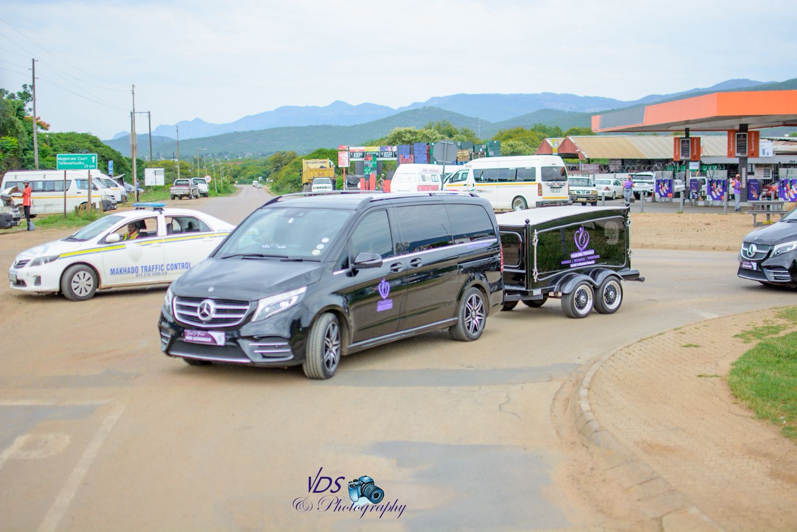 Hearse with glass carriage on road
